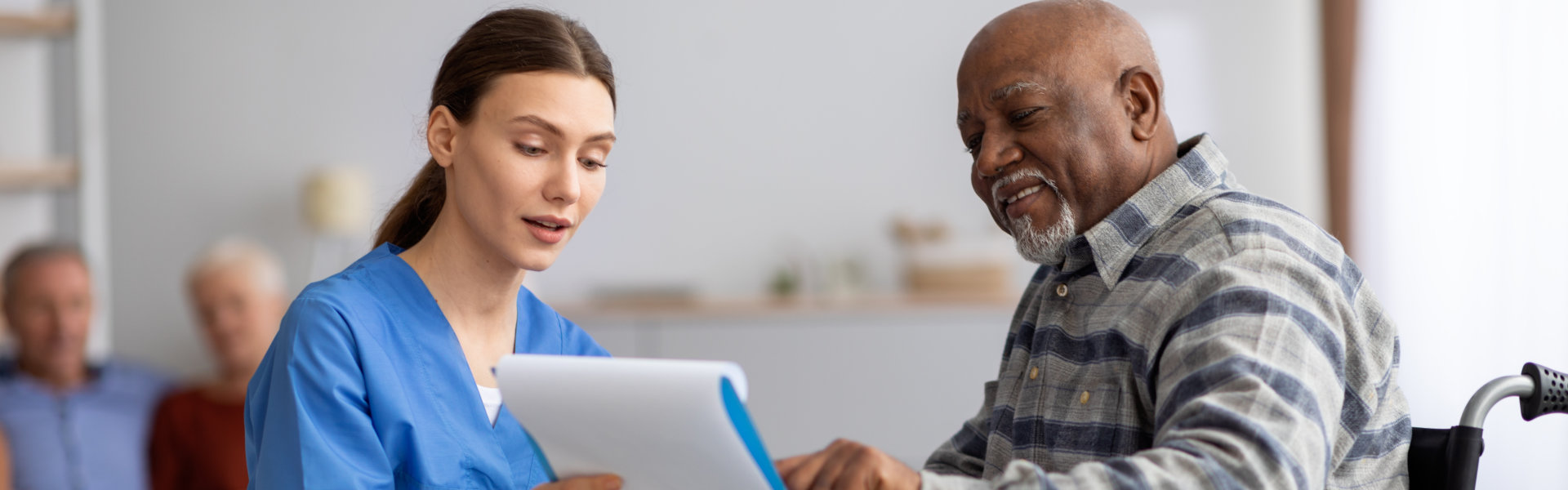 caregiver and senior man signing